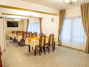a row of tables and chairs in a room at Pensiunea Agroturistica Stefan Viorica in Moldoviţa