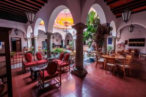 a restaurant with red chairs and tables in a building at Hotel Posada Casa de la Tía in Oaxaca City