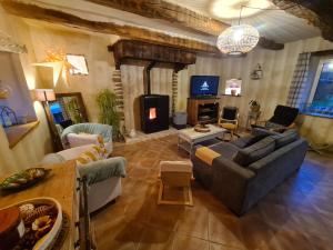 ein Wohnzimmer mit zwei Sofas und einem Fernseher in der Unterkunft Kêr Neizh Breizh - Gîtes de Charme - Le Petit Châtelier in Saint-Samson-sur-Rance