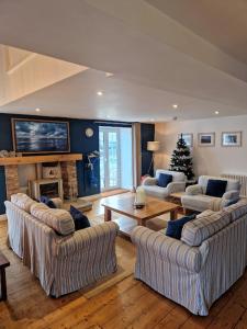 a living room with three couches and a fireplace at The Old Mill, Deluxe holiday home with a view in Menai Bridge