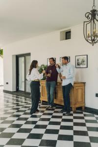 un grupo de tres personas de pie en una habitación en Viamonte Winery Lodge, en Chacras de Coria 51 fotos más