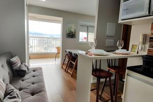 a kitchen and living room with a couch and a table at Aeroporto GRU e Shopping Maia, com Ar Condicionado in Guarulhos