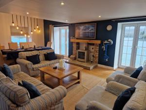 a living room with couches and a table and a fireplace at The Old Mill, Deluxe holiday home with a view in Menai Bridge