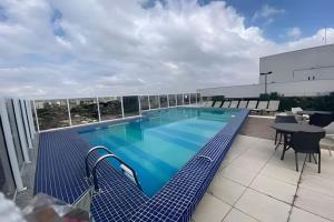 a swimming pool on the roof of a building at Aeroporto GRU e Shopping Maia, com Ar Condicionado in Guarulhos