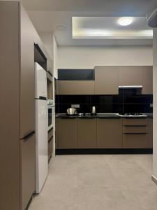 a kitchen with brown cabinets and a white refrigerator at Sogular Apartments 1 in Aglantzia