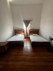 two beds in a room with a window at Casa-Hostal La Casona in Roldanillo