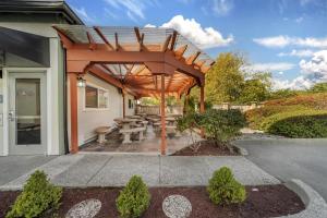 a wooden pergola on a patio with a table and benches at Best Western Plus Northwoods Inn in Crescent City