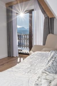 een slaapkamer met een bed en een raam met uitzicht bij Apartamenty i Pokoje Gościnne U Trebuni in Murzasichle