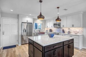 een keuken met witte kasten en een blauwe kom op een aanrecht bij Beach-2-Green - 3BR condo w golf views & pool in Ponte Vedra Beach