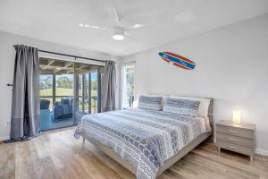een slaapkamer met een bed en een groot raam bij Beach-2-Green - 3BR condo w golf views & pool in Ponte Vedra Beach +44 foto's