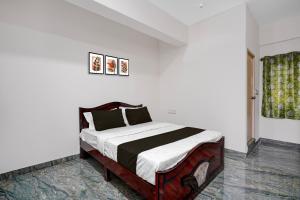 a bedroom with a large bed in a room at Hotel O Bhuvika Residency in Jālahalli +21 photos