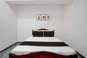 a bedroom with a large bed in a white room at Hotel O Bhuvika Residency in Jālahalli