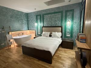 a bedroom with a bed and a bath tub next to a bath tub at Ursachi Apartaments & Rooms in Suceava