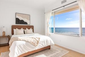 a bedroom with a bed and a large window at Gorgeous Malibu Retreat with #Instaworthy Ocean Views in Malibu Beach +37 photos