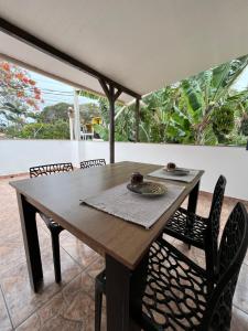a wooden table and chairs on a patio at Casinhas da toca in Búzios