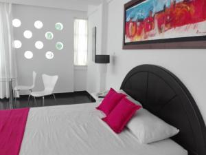 ein Schlafzimmer mit einem großen Bett mit rosa Kissen in der Unterkunft Hotel Paraiso Estudios in Ricaurte
