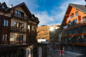 un grupo de edificios con una montaña en el fondo en New Gudauri apartments by ProGudauri, en Gudauri
