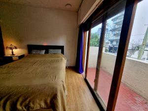 una camera da letto con un letto e una grande finestra di La Hélice a Puerto Madryn