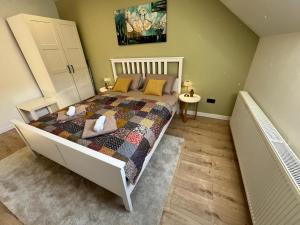 a bedroom with a bed with a quilt on it at Apartman Old Corner in Virovitica