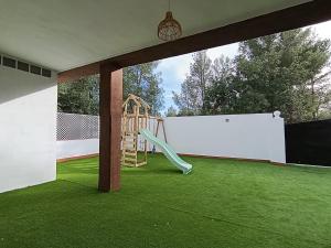 a playground with a slide on a green lawn at El otro cielo Playamonte in Navarrés