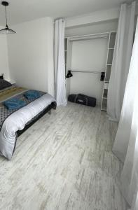 Habitación blanca con cama y armario en La petite maison des bleuets, en Romorantin-Lanthenay 2 fotos más