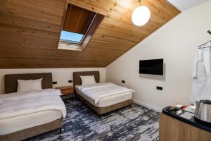 Una habitación de hotel con dos camas y un televisor. en Nouvelle Hotel, en Oni 33 fotos más