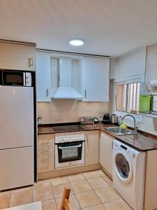 a kitchen with a white refrigerator and a dishwasher at Apartamento Sant Josep in Canet de Mar