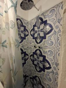 een douche met een blauw-wit douchegordijn bij Palazzo Rubina - Dimora mediterranea & SPA in Torre del Greco