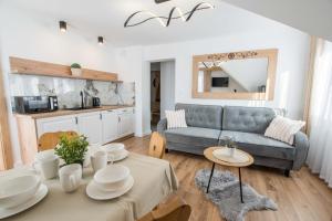een woonkamer met een bank en een tafel bij Apartamenty i Pokoje Gościnne U Trebuni in Murzasichle