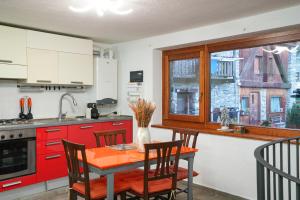 una cucina con armadi rossi e un tavolo con sedie di Roisan Apartment a Castello Altre 7 foto