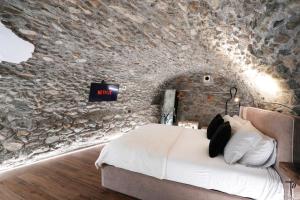 una camera da letto con un letto in un muro di pietra di Roisan Apartment a Castello