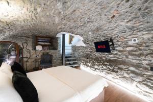 una camera da letto con un letto e un muro di pietra di Roisan Apartment a Castello