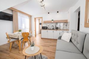 een woonkamer met een bank en een tafel bij Apartamenty i Pokoje Gościnne U Trebuni in Murzasichle