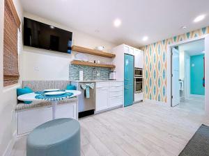 a kitchen with a table and a tv on a wall at Reel Paradise steps to bay beach fishing dock in Bradenton Beach