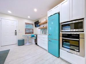 a kitchen with a blue refrigerator and white cabinets at Reel Paradise steps to bay beach fishing dock in Bradenton Beach