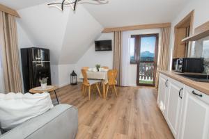 een keuken en woonkamer met een tafel en een bank bij Apartamenty i Pokoje Gościnne U Trebuni in Murzasichle +52 foto's