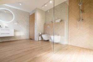 a bathroom with a shower and a toilet and a sink at Apartamenty i Pokoje Gościnne U Trebuni in Murzasichle