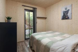 a bedroom with a bed in a room with a window at Unique Hideaway by Krøderen - Beach, Boat & Hiking in Ørgenvika