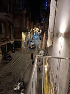 een stadsstraat 's nachts met mensen die over straat lopen bij Palazzo Rubina - Dimora mediterranea & SPA in Torre del Greco