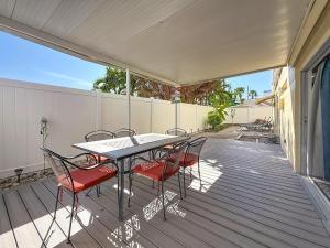 un patio avec une table et des chaises sur une terrasse dans l'établissement Waves 1, à St. Pete Beach