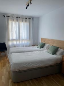 a bedroom with two beds and a window at Casa Marali Ski & Bike Formigal in Formigal +26 photos