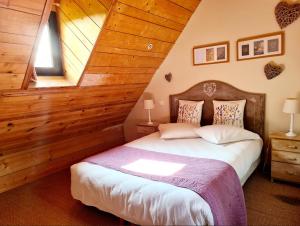 ein Schlafzimmer mit einem Bett mit einer Holzwand in der Unterkunft Kêr Neizh Breizh - Gîtes de Charme - Le Petit Châtelier in Saint-Samson-sur-Rance