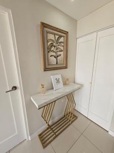 a console table in a hallway with a picture on the wall at Portmore Paradise in Portmore +11 photos