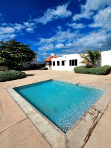 a swimming pool in front of a white house at Portmore Paradise in Portmore