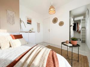 a white bedroom with a bed and a table at Le Sky - Penthouse d'Exception avec Vue Panoramique et Terrasse en Plein Cœur d'Orsay Paris-Saclay in Orsay