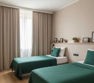 a hotel room with two beds with green sheets at Hotel Clina in Adana