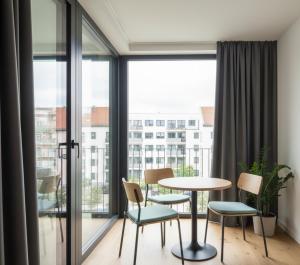 a room with a table and chairs and a large window at Hotel Clina in Adana
