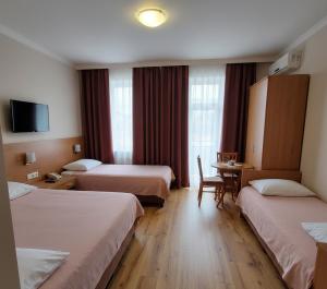 a hotel room with two beds and a table at Hotel Clina in Adana +17 photos
