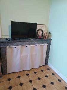 una TV a schermo piatto seduta sopra un bancone di Studio chez Claudine a Conches-en-Ouche