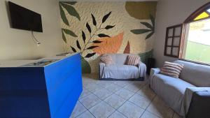 uma sala de estar com uma TV e um sofá em Almar Hospedagem 2 ARRAIAL DO CABO em Arraial do Cabo